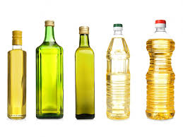A row of different bottles of oil and cooking oils.